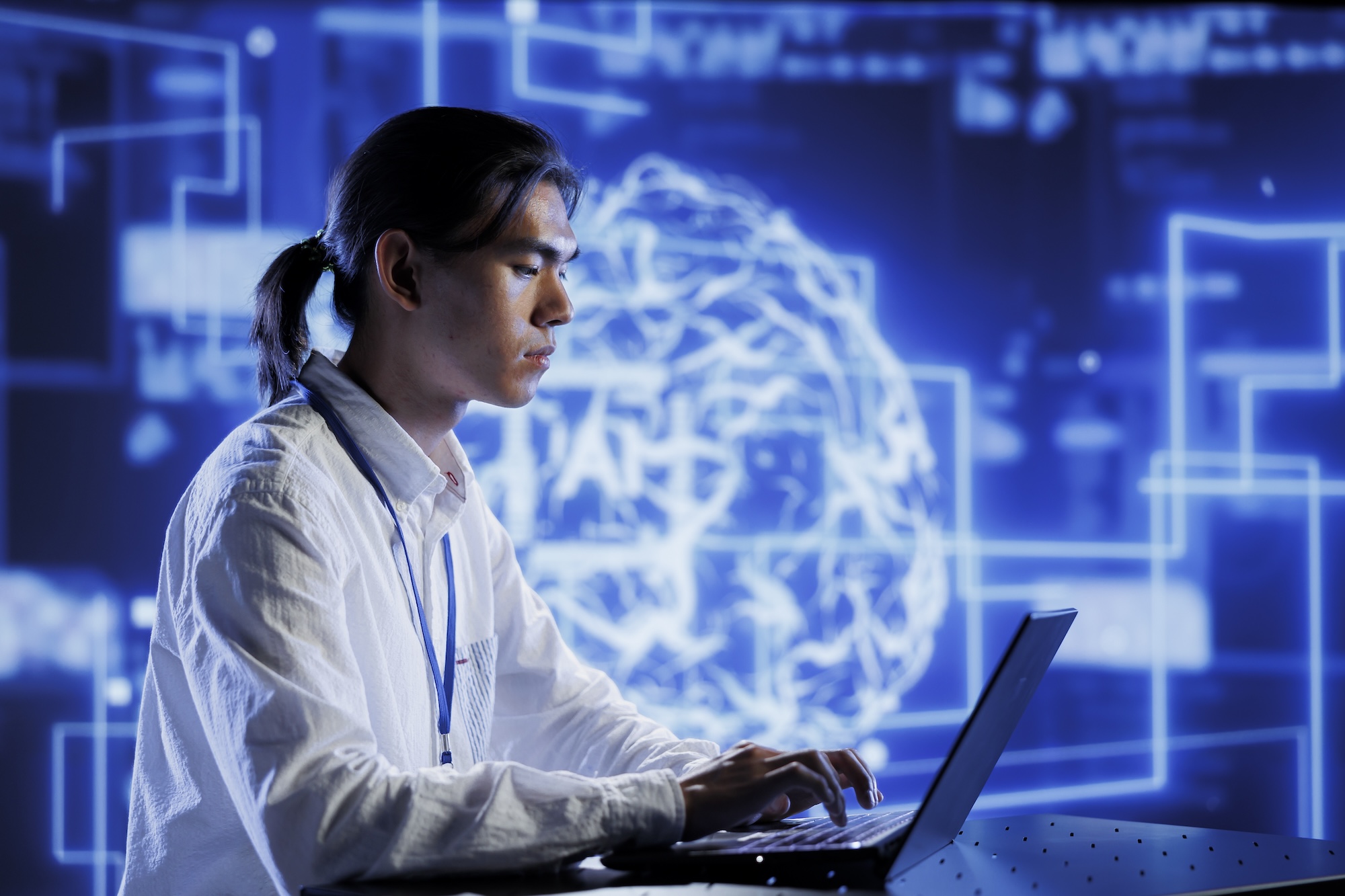 Trained technician in data center uses artificial intelligence computing simulating human brain through self learning algorithms. Knowledgeable expert with laptop working with AI deep neural networks